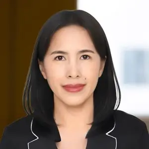 A woman with straight black hair, wearing a black blazer with white trim, stands confidently in front of a blurred background—her focus keyphrase not set.